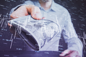 Multi exposure of financial graph drawing hologram and USA dollars bills and man hands. Analysis concept.