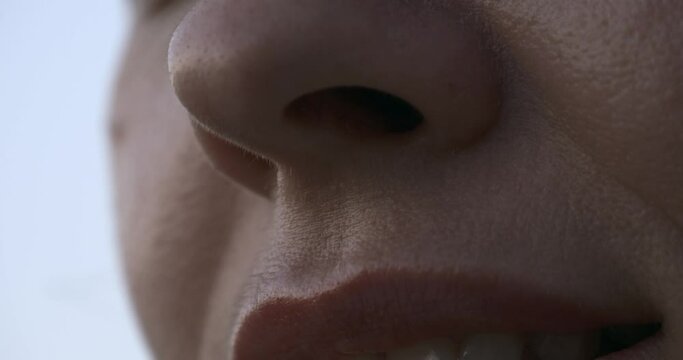Tilting up close-up Female Face. Mouth Lips Nose Eyes. Outdoors Natural Lighting Morning Evening Time