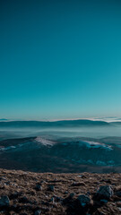 Mountain climbing, popular tourist attraction, impressive view, mountains are covered in fog, winter sunset, fantastic view. Dramatic wintry scene. Wallpaper for phone