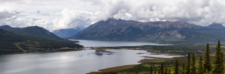 Beautiful Panoramic View of a small Touristic Town, Carcross, surounded by Canadian Mountain Landscape. Located near Whitehorse, Yukon, Canada.