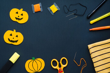 preparation for terrible holiday. Top view of Halloween decorations, sewing items making textile pumpkin, craft handmade on black background, copy space, place for text