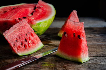 Ripe sliced watermelon on slices on a wooden table.