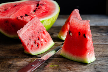 Ripe sliced watermelon on slices on a wooden table.