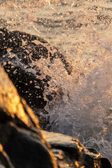 Close up of waves crashing on the rocky coast at Kullaberg nature reserve in south Sweden. Selective focus.