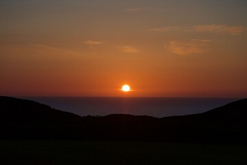 sunset over the sea between cliffs 