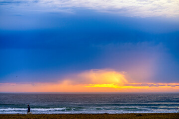 Obraz premium Sunset with sunlight through clouds, beach, ocean 
