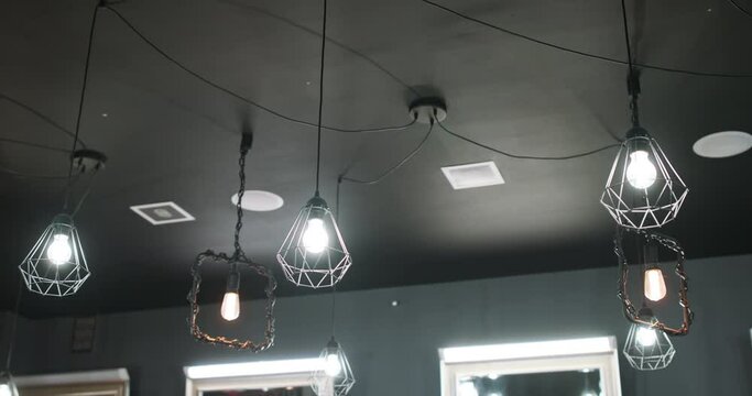Vintage luxury interior modern lighting, hanging on the ceiling of barbershop. Grey ceil, grey walls.