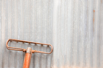 Vintage corrugated metal plates with old mop stick (cleaning equipment) show vertical line texture...