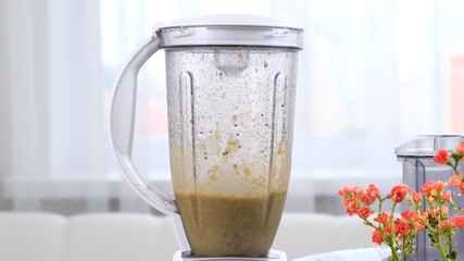 Close-up of healthy green smoothie, detox cocktail preparing in blender