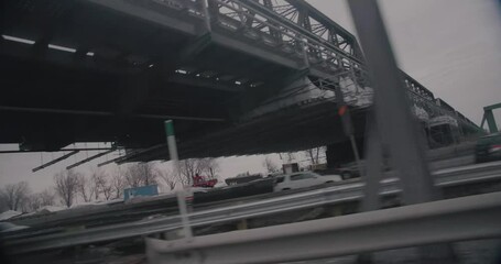 Montreal, Canada - November 15th 2017 : Worm eye dutch angle shot of victoria bridge filmed while driving on Quebec Autoroute 10, cars traffic on the Highway