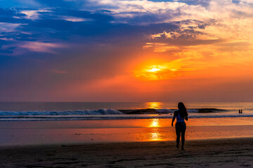 Fototapeta na wymiar Silhouetted Person on beach at Sunset, Ocean 
