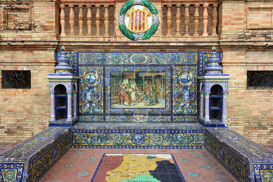 Image with the name of the spanish city of  Lerida with a historical scene painted on ceramic tiles, with and the emblem shield above - seating benches in Spain Square in Seville