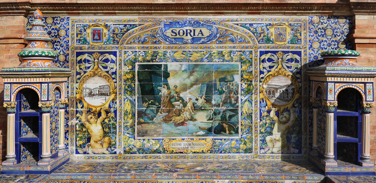 Image with the name of the spanish city of Soria and a historical scene painted on ceramic tiles - seating benches in Spain Square in Seville