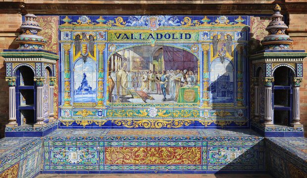 Image with the name of the spanish city of Valladolid and a historical scene painted on ceramic tiles - seating benches in Spain Square in Seville