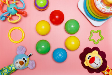 Children's toys on a pink background, copy space in the center for creative design. Flat lay.