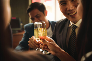 asian business couple toasting and clinking wine or champagne together