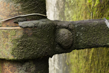Support bracket for diesel supply pipe with an accumulation of waste oil at an abandoned factory.
