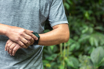 Man running on the mountain looks at his Smartwatch