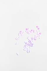 simple medicine concept. pills and capsules of pink color on a white background. flat lay