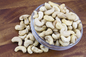 Cashew nuts in glass bowl on wooden table