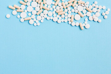 medicine concept. vitamins and pills to maintain healthy skin and hair. simple flat lay on a blue background, space for text