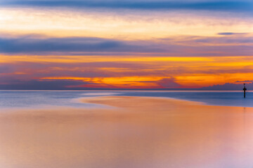 Fototapeta na wymiar Long exposure minimalist sunset over sea with text space. Beautiful vivid golden orange colors