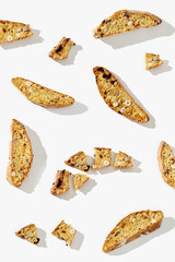 Several pieces Italian biscotti cookies on white background. Fresh broken cookies with nuts and...