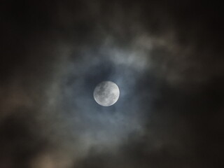 Naklejka na ściany i meble Moon peaking through cloud