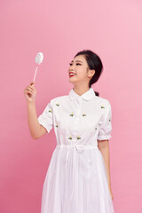 Young pretty woman with candies on colorful background