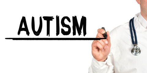 Doctor writes the word - AUTISM. Image of a hand holding a marker isolated on a white background.