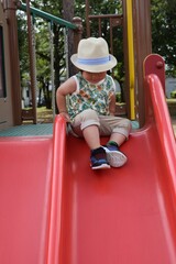 公園のすべり台で遊ぶ3歳の男の子
