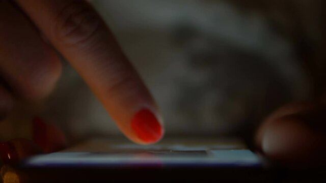 Hand with a smart phone in a dark