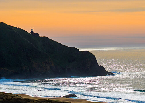 California Lighthouse At Sunset With Orange And Purple Sky