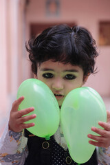 Fototapeta na wymiar Cute Indian Boy Kid Playing With Balloons.