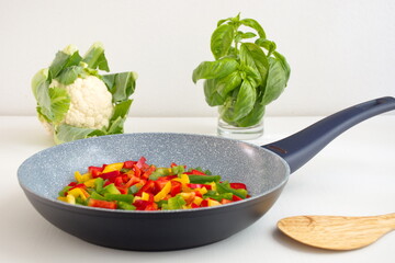 Frying pan and colorful vegetables on white background