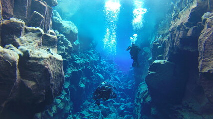 Naklejka na ściany i meble bubbles rising to reflective glacial water underwater surface whilst scuba diving in iceland
