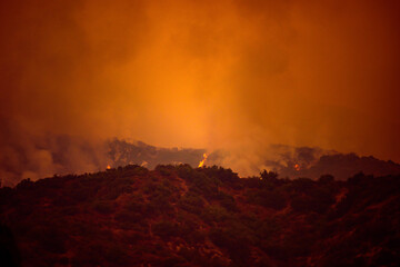 Orange sky over the mountains of California. Fires near Los Angeles. Smoke pollution in US air.