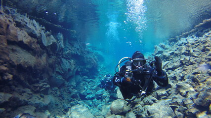 diver in drysuit swimming in icelandic glacial water