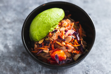 plant-based food, vegan salad bowl with teriyaki sauce salad mix almonds and avocado
