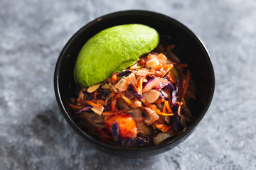 plant-based food, vegan salad bowl with teriyaki sauce salad mix almonds and avocado
