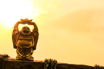 Laughing Buddha. God of Hotei. Gold figurine. Buddhism. - Powered by Adobe