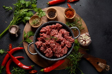 Minced beef. Ground meat with ingredients for cooking on black background