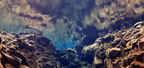 underwater reflection of rocky canyon in iceland, silfra