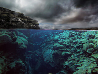 Under and over shot of dramatic cloudy canyon in glacial spring water ravine, Silfra, Iceland