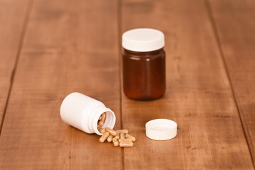 Spill pills from the white can on the wooden table.