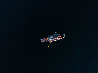 Naklejka premium Attractive Woman on Stand Up Paddle Board, Woman paddling on sup board and enjoying turquoise transparent water. Tropical travel, wanderlust and water activity concept. Sunset and relax
