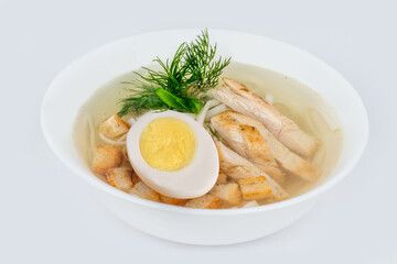Chicken soup with meat, egg and fresh herbs