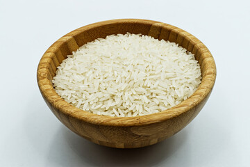 Uncooked Basmati rice in a wooden bowl, isolated on white background
