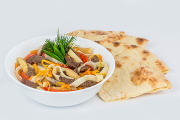 Lagman in a white, round plate with a flatbread