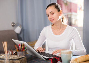 Smiling girl sitting at table at home calculating domestic finances and bills. High quality photo